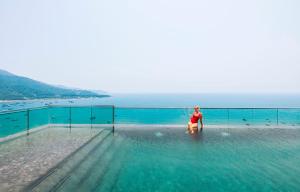 kobieta stojąca w wodzie w basenie w obiekcie The Code Hotel & Spa Da Nang w mieście Da Nang