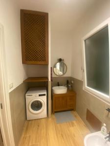 a small bathroom with a washing machine and a sink at Villa Ortensia in Cefalù +56 photos