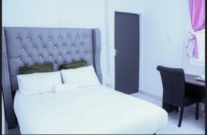a bedroom with a white bed with a desk and a bed sidx sidx sidx sidx at 4 Callington guest house in Gqeberha