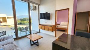 a living room with a couch and a tv at Hotel y Departamentos Sofia in Rincon de Guayabitos