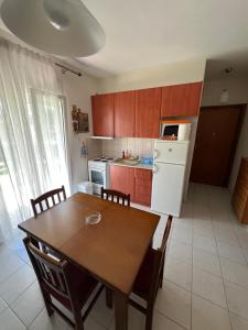 a kitchen with a table and a white refrigerator at Family house in Skála Foúrkas
