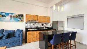 a kitchen with a blue couch and a kitchen island at Hotel y Departamentos Sofia in Rincon de Guayabitos