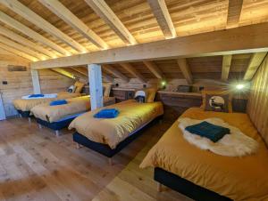 3 łóżka w pokoju z drewnianym sufitem w obiekcie Chalet l'Appel de la Forêt w mieście Gérardmer