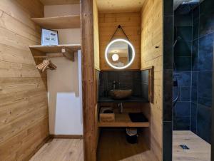 łazienka z umywalką i lustrem w obiekcie Chalet l'Appel de la Forêt w mieście Gérardmer