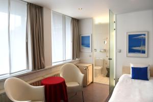 ルーセラーレにあるHotel Vijfwegenのベッド、赤いテーブルと椅子が備わるホテルルームです。