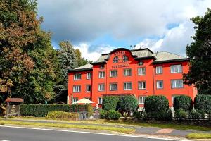 un grande edificio arancione con un cartello sopra di Active & Wellness Hotel Subterra a Ostrov