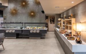a restaurant with a buffet of food on display at Rise Urban Art Hotel in Larnaca