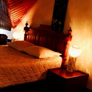 a bedroom with a bed and two lamps on tables at Le fumoir guest house familiale in Antananarivo