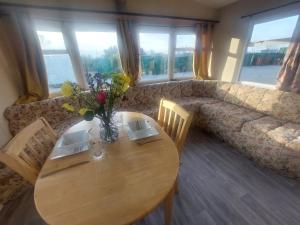 a wooden table with a vase of flowers on it at Cozy Caravans in Ramsgate in Ramsgate +24 photos