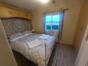 a bedroom with a bed with towels on it at Cozy Caravans in Ramsgate in Ramsgate