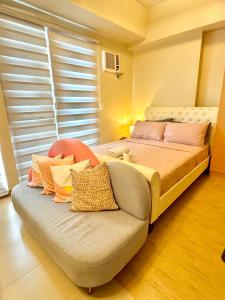 a bed and a couch in a room at The Palladium - Modern Executive Studio in Iloilo City +36 photos