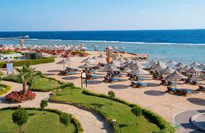 a beach with umbrellas and chairs and the ocean at Charmillion Sea Life Resort in Sharm El Sheikh