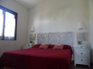 a bedroom with a large bed with a red bedspread at Nachetes 1 in Cala Blanca +9 photos