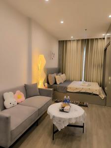 a living room with a couch and a bed at Vinhomes Smartcity- Căn hộ dịch vụ nguyên căn in Phú Thú