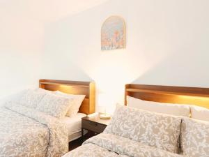 a bedroom with two beds and a table with a lamp at HeiStay-30sec from Hongdae SubwayStop-Elevator in Seoul