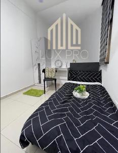 a bedroom with a black and white bed and a chair at Residensi prima kampung paloh in Ipoh