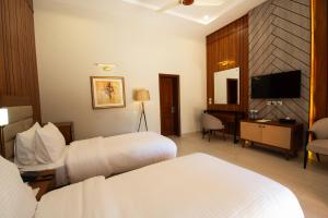 a hotel room with two beds and a television at Green Pak Resort Fort Munro in Fort Monroe
