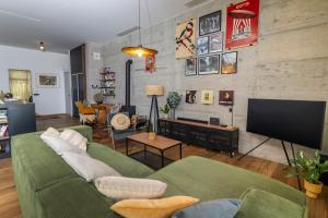 a living room with a green couch and a flat screen tv at Zen House in Zadar