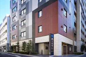 a tall building with a sign in front of it at Minn Nihonbashi in Tokyo +3 photos