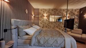 a bedroom with a bed and a chair and a mirror at Vakantiewoning Hem in Hem