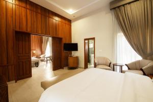 a bedroom with a large white bed and a television at Green Pak Resort Fort Munro in Fort Monroe