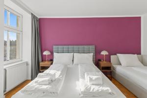 ウィーンにあるCozy Living Apartment "Falco" - free parkingの紫の壁のベッドルーム1室(白いベッド1台付)
