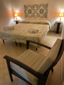 a room with two beds with a chair and a table at Norman City House in Palermo