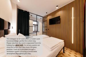 a bedroom with a bed and a tv on a wall at Main Square Rooms in Maribor