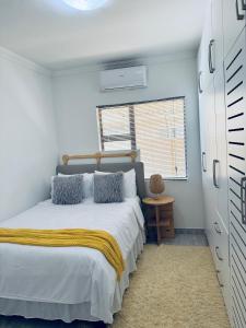 哈博罗内LOR Homes的卧室里有一张床,床上铺着一条黄色的毯子