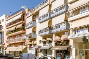 a building with balconies and cars parked on a street at NT Studio in Igoumenitsa