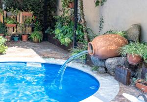 a pool with a water fountain in a yard at Hanami House Boutique 4 Estrellas Valle del Jerte in Navaconcejo
