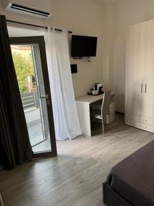 a room with a bed and a desk with a window at Affittacamere Mary's Rooms in San Teodoro