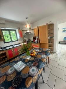 Una cocina con una mesa con un bol de fruta encima. en Villa meublé Tourisme 4 etoiles Sous le Ficus piscine chauffée - Ouest Lagon, en Saint-Paul