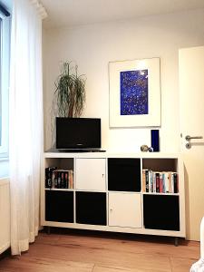 una sala de estar con un centro de entretenimiento blanco con TV en Ferienwohnung am Campus, en Oldenburg