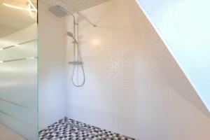 a shower in a bathroom with a black and white tile floor at Harzträume No2 mit Parkplatz - Zentrum - Brockenbahn - 2 SZ in Wernigerode +22 photos