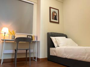 um quarto com uma cama e uma escrivaninha com uma cadeira em Greenfield Residence Sunway Pyramid em Kuala Lumpur mais 95 fotografias