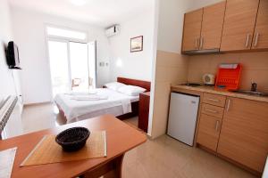 a small room with a bed and a kitchen at Apartments Baron in Sveti Stefan