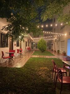 a patio with tables and chairs and lights at Hotel Palace Piriápolis in Piriápolis