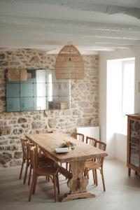 a dining room with a wooden table and chairs at Maison rénovée à 80m de la plage, charme et confort in Saint-Jacut-de-la-Mer