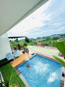 a person swimming in a swimming pool on top of a house at Oceanview Exclusive Home Villanueva Jasaan in Jasaan