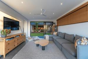 a living room with a couch and a tv at Theunieskraal Nkwazi Ridge Estate in Zinkwazi Beach