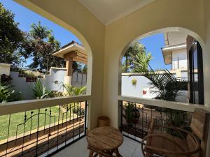 a balcony with two windows and a table and chairs at Town Retreat Moshi in Moshi