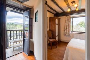 ein Schlafzimmer mit einem Bett und einem Balkon in der Unterkunft La Casona in San Vicente de la Barquera