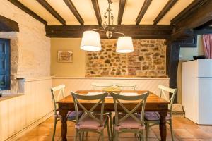 ein Esszimmer mit einem Holztisch und Stühlen in der Unterkunft La Casona in San Vicente de la Barquera