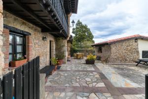 eine Außenterrasse mit einer Bank und einem Gebäude in der Unterkunft La Casona in San Vicente de la Barquera