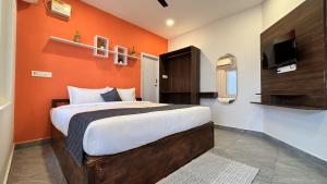 a bedroom with a bed with an orange wall at Ta Cabana Beach house-Pondicherry in Pondicherry