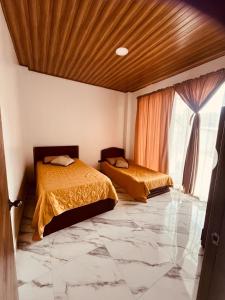 2 Betten in einem Zimmer mit Marmorboden in der Unterkunft Carachula Guesthouse in Macas