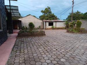 eine Backsteineinfahrt mit einem Gebäude im Hintergrund in der Unterkunft Carachula Guesthouse in Macas