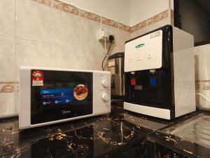 un forno a microonde seduto su un bancone accanto a una macchinetta del caffè di Amanjiwa Villa - Private Pool a Kampong Pulau Sebang