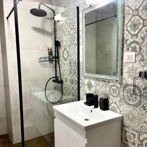 a bathroom with a shower and a sink and a mirror at V&P Apartments in Bitola